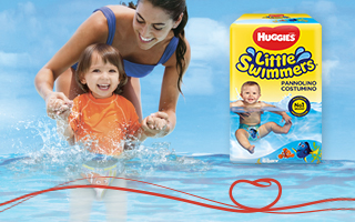 Mamma e figlio che giocano e ridono in acqua con Huggies® Little Swimmers